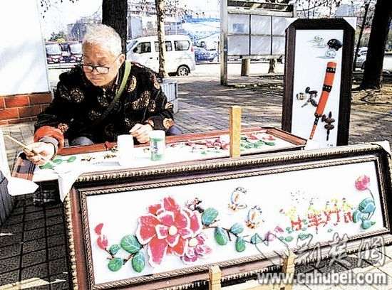 图为：范培仁和他的石头画