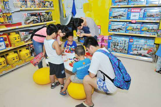 小朋友跟家长一一起在玩具反斗城体验玩具